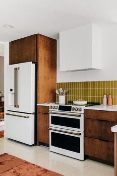 a white stove top oven sitting inside of a kitchen next to a refrigerator freezer