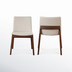 two chairs sitting side by side in front of a white background with one chair facing the other