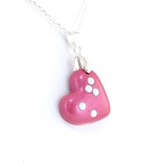 Choose any 1-2 letters in braille on this adorable heart shaped pendant. The necklace is made out of polymer clay in a silver plated bail/loop with your choice of clay color. It comes with a choice of silver plated chain or leather cord (18-20 inches) and white or black metal dots. The pendant is sealed with a coat of glaze. The heart measures 1-3/8 inches tall (35mm) including bail/loop 1 inches across (25 mm) This example is made of medium (2 letter) and dark (1 letter) magenta clay but can be Cute Heart Print Jewelry Gift, Cute Heart Print Jewelry For Gift, Nickel-free Polymer Clay Necklace Gift, Silver Polymer Clay Pendant Necklace, Cute Nickel-free Heart-shaped Necklace, Cute Nickel-free Heart Necklace, Pink Polymer Clay Necklace For Gift, Pink Polymer Clay Jewelry With Heart Beads, Pink Polymer Clay Necklace For Gifts