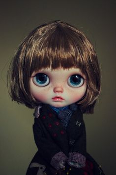 a close up of a doll with blue eyes