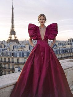 a woman standing on top of a roof next to the eiffel tower