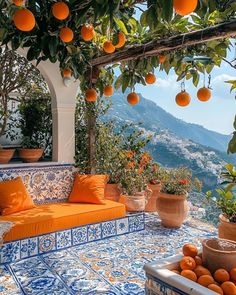 an orange tree with lots of oranges hanging from it's branches and some potted plants