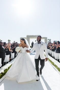 a bride and groom walking down the aisle