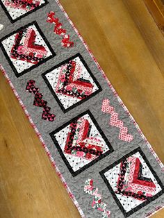 a quilted table runner with hearts and arrows on it