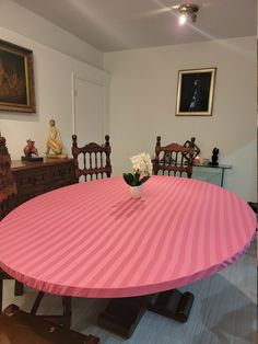 a pink and white striped table cloth on a dining room table