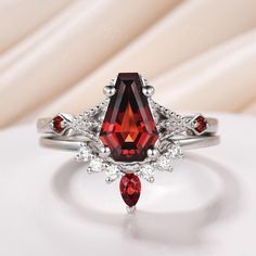 a ring with a red stone surrounded by white diamonds