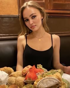 a woman sitting at a table full of food