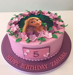 a pink and purple birthday cake with the number five on it's side, decorated with flowers