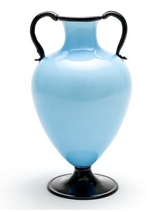 a light blue vase with black handles is on a stand against a white background,