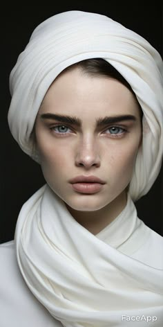 a woman with blue eyes wearing a white head scarf