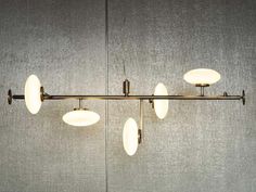 an image of a modern light fixture hanging from the ceiling with four lights on it