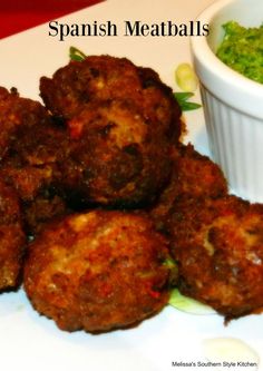 some food is sitting on a plate next to a small white bowl with pesto