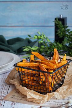 a basket filled with french fries sitting on top of a table