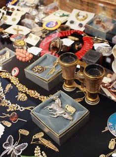 a table topped with lots of different types of jewelry on top of a black table