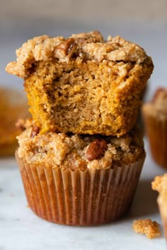 two muffins stacked on top of each other with one cut in half to show the inside