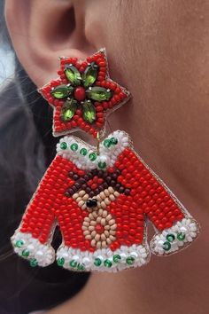 We only have limited quantities of these! Beaded-Lightweight!  Handcrafted Christmas Sweater Earrings!  Featuring Rudolf and his red nose, these Christmas sweater earrings are the icing on top of your holiday outfit!   Earrings are approximately 2.5 inches long and 2 inches wide at the widest point.  This is a handcrafted item and ships from a family owned small business in Texas. Handmade Beaded Earrings For Christmas, Christmas Party Beaded Earrings With Round Beads, Festive Christmas Beaded Earrings, Handmade Red Beaded Earrings For Holiday, Red Beaded Earrings For Christmas, Holiday Red Handmade Beaded Earrings, Red Beaded Earrings For Christmas Party, Red Beaded Earrings For Holiday Party, Holiday Red Beaded Earrings