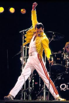 elvis presley performing on stage with his arms in the air