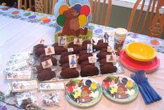 a table topped with lots of desserts and chocolate candies covered in teddy bears