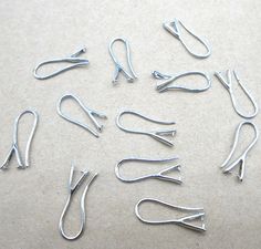 several pairs of metal clips on a white surface