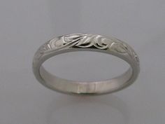 This is my Vine and Leaf Hand Engraved Wedding Band in Palladium white gold, it is a wonderful alternative to the standard 14k white gold which has nickel in it and causes an adverse reaction for some people and is referred to as nickel itch. Band shown in a size 7. Add $50 per size over a size 7. Vine Leaf copyright 2009 Hand Engraved Wedding Band, Engraved Wedding Band, Wedding Band Engraving, Engraved Wedding, Gold Engraving, Gold Hand, White Gold Band, Gold Hands, Hand Engraving