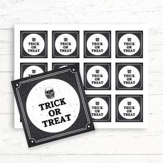 trick or treat stickers on top of a white wooden table next to a black and white photo