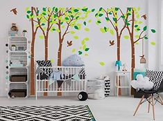 a baby's room with trees and birds painted on the wall