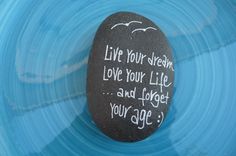 a rock with the words live your dreams love your life and forget your age written on it