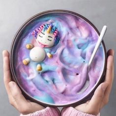 someone is holding a bowl with unicorn food in it