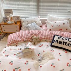 there is a teddy bear on the bed with pillows and pillowcases in this room