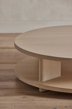 a round wooden table with two shelves on each side