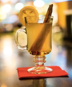 a glass mug filled with liquid and cinnamon sticks