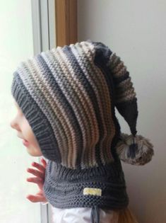 a small child wearing a knitted hat and scarf