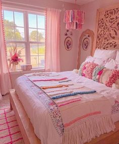 a bedroom with pink walls, white bedding and decorative accessories on the headboard