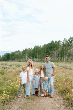 a family posing for a photo in the middle of a field with wildflowers