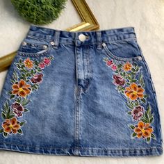 Forever 21 Jean Skirt With Embroidered Flowers Gently Used! Beautiful Jean Skirt With Embroidered Flowers On Each Side. Please See Pictures With Measurements. Size: Xs Spring Floral Embroidered Fitted Mini Skirt, Fitted Floral Embroidered Mini Skirt For Spring, Embroidered Jean Skirt, Casual Embroidered Skirt For Spring, Fitted Floral Embroidered Mini Skirt For Summer, Casual Summer Mini Skirt With Floral Embroidery, Blue Floral Embroidery Skirt For Spring, Spring Floral Embroidered Mini Skirt, Spring Embroidered Denim Skirt