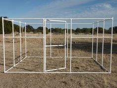 a white metal structure sitting in the middle of a field