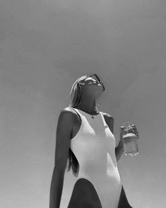 a woman in a bathing suit holding a water bottle