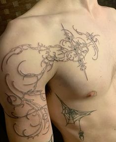 a man with a spider web tattoo on his arm and chest is looking at the camera