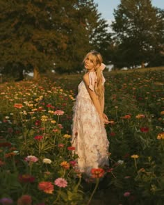 a woman standing in a field full of flowers