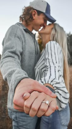 a man and woman holding hands while standing next to each other