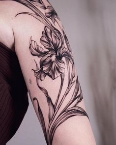 a woman's arm with a flower tattoo on the left side of her arm