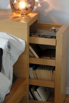 a bedroom with a lamp on the nightstand next to a book shelf filled with books