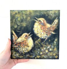 a painting of two birds sitting on top of a leaf covered ground next to each other