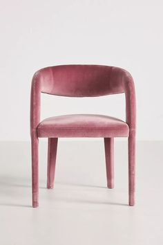 a pink chair sitting on top of a white floor