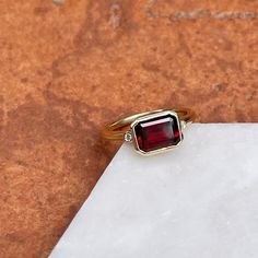 14KT yellow gold bezel-set octagonal/ emerald-cut Mozambique red garnet + accent diamond ring. Stunning, deep red color! Garnet is the birthstone for January babies- and this piece makes a birthstone ring/ engagement ring! Since this is a custom piece, each garnet will vary slightly from stock photo. Can also be made with a different gemstone instead of garnet- please reach out for pricing, as it varies on each gemstone. Size 7 Can be resized for an additional fee Weight: 4.00 grams Band width: Red Octagon Jewelry For Formal Occasions, Red Octagon-shaped Jewelry For Formal Occasions, Red Octagon Formal Jewelry, Red Octagon Fine Jewelry, Octagon Ruby Ring As A Gift, Classic Faceted Ruby Jewelry, Red Diamond Radiant Cut Jewelry, Fine Jewelry Ruby With Radiant Cut, Red Radiant Cut Diamond Jewelry