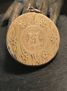 "Early 1900s hand engraved floral motif large round locket.  Condition is good for it's age-the inside has soft solder  from previous owner-pictures will cover it and it does not effect the design when closed.  size 1 1/8\" in diameter, monogram I believe is a G.  Artistically engraved." Vintage Engraved Rose Gold Jewelry, Victorian Medallion Locket Necklace With Filigree, Victorian Filigree Medallion Locket Necklace, Victorian Style Medallion Locket Necklace With Filigree, Victorian Style Filigree Medallion Locket Necklace, Victorian Jewelry With Coin Pendant, Antique Engraved Flower Pendant Locket Necklace, Antique Coin Pendant Jewelry, Antique Engraved Locket Necklace With Flower Pendant