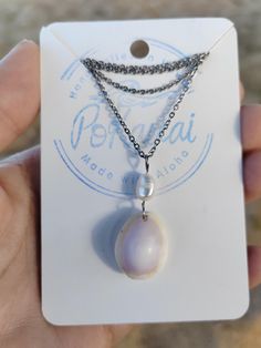 Adorn yourself with the beauty of Hawaii with this stunning handmade stainless steel Hawaiian honey cowry shell and freshwater pearl pendant, shell found on the beaches of Kauai Hawaii. Unique and elegant, this piece captures the essence of the islands, perfect for any ocean lover.  Handmade in Hawaii with a lot of Aloha! Perfect for leyering 16" flat cable chain Made of stainless steel Authentic shell from Kauai Hawaii Shell gift with purchase! U.S. shipping included.  SIZE : Shell 0.7" Chain 1 Hawaii Gift, Cowry Shell, Kauai Hawaii, Ocean Lover, Gift With Purchase, Shell Necklace, Unique Gifts For Her, Shell Necklaces, Kauai