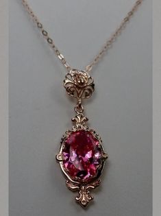 This is a rose gold plated over sterling silver Victorian reproduction pendant with a flawless simulated gemstone. The stunning man made 6 carat gem is 14mm long and 10mm wide. The pendant is 1.75" long. The necklace (if chosen) is adjustable between 18"-20". The pendant and chain are marked 925 for sterling silver. Classic Rose Gold Gemstone Jewelry, Luxury Rose Gold Oval Pendant Jewelry, Formal Rose Gold Oval Pendant Necklace, Exquisite Hallmarked Rose Gold Jewelry, Rose Gold Gemstone Pendant Jewelry, Exquisite Rose Gold Jewelry With Elegant Design, Rose Gold Oval Pendant Jewelry Gift, Rose Gold Jeweled Necklaces For Gifts, Pink Jeweled Jewelry For Formal Occasions