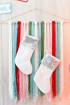 two christmas stockings hanging on a wall with fringes and tassels around them