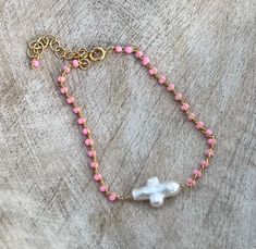 "Freshwater cross pearl  on a gold filled pink beaded chain with a 1.5 inch extender and dangle bead.   Bracelet measures 6.5\" plus the 1.5\" extender chain.  Beautiful alone or paired with other bracelets.  AAA quality pearls, each pearl is uniquely different.  Pearl cross measures approximately 1/2\" x 1/4\" inch.  Minimalist and delicate bracelet.  Perfect Easter or First Holy Communion gift! If you need a custom smaller or larger size please leave a message on your order. I can customize wi Pearl Cross Bracelet, Pink Cross Bracelet For Gifts, Pink Cross Rosary Bracelet Gift, Pink Cross-shaped Jewelry For Gift, Pink Adjustable Cross-shaped Bracelets, Communion Gifts, Cross Bracelet, Minimalist Bracelet, Wedding Jewelry Bracelets